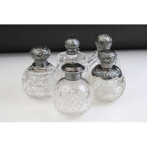 490 - Group of silver topped cut glass scent bottles including four of orb form and one square example. Ea... 