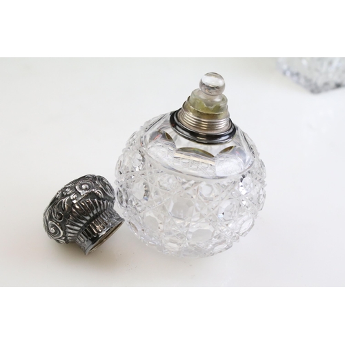 490 - Group of silver topped cut glass scent bottles including four of orb form and one square example. Ea... 