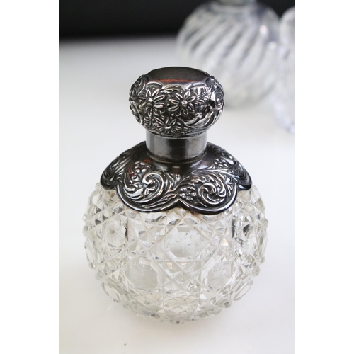 490 - Group of silver topped cut glass scent bottles including four of orb form and one square example. Ea... 