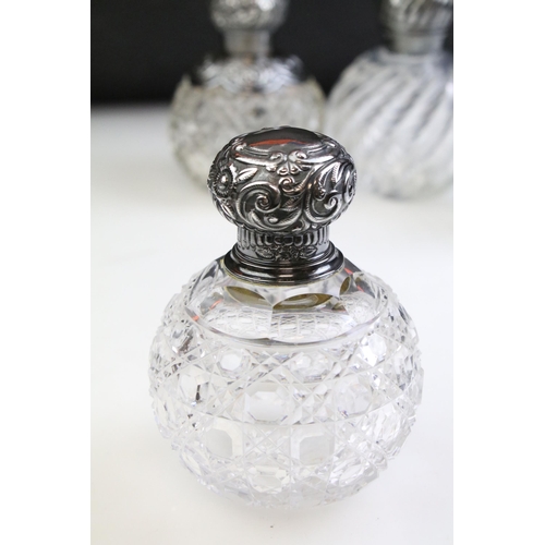 490 - Group of silver topped cut glass scent bottles including four of orb form and one square example. Ea... 