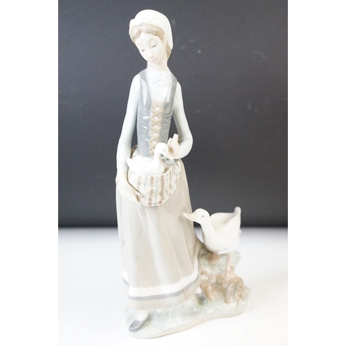 27 - Collection of three Lladro figurines of girls with geese and a lamb, 30cm tallest, all stamped at ba... 