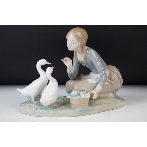 27 - Collection of three Lladro figurines of girls with geese and a lamb, 30cm tallest, all stamped at ba... 