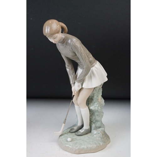 38 - Lladro porcelain figurines of girl playing golf, 27.5cm tall and turtle dove in flight 28cm tall. Ma... 