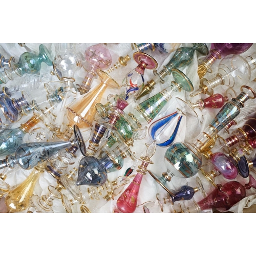 45 - Collection of 20th century coloured glass scent bottles in varying sizes and shapes with intricate d... 