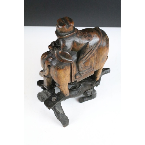 114 - Antique Chinese hand carved wooden figure of horse and rider set on natural wooden branch base, 31cm... 