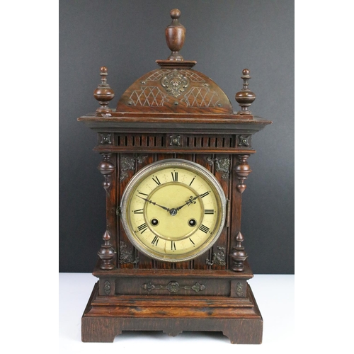 121 - Antique mantel clock with attractive carved wood case, complete with key. 50cm high, 27cm wide and 1... 