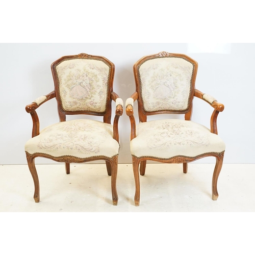 600 - Pair of 20th Century arm chairs having carved wooden framed with floral upholstered seats.