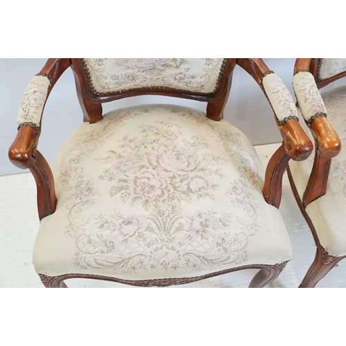 600 - Pair of 20th Century arm chairs having carved wooden framed with floral upholstered seats.