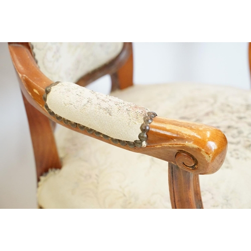 600 - Pair of 20th Century arm chairs having carved wooden framed with floral upholstered seats.