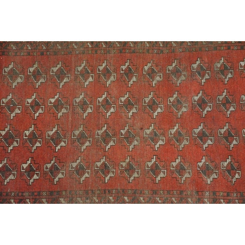 614 - Islamic floor carpet rug having a red ground with geometric medallions to centre surrounded by geome... 