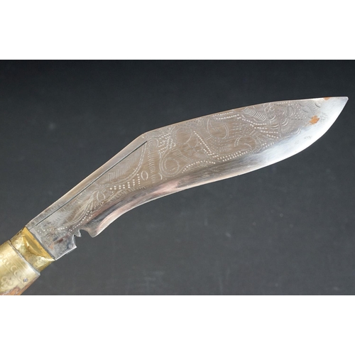 100 - A mid 20th century Kukri knife, decorative dot engraved steel blade, wooden handle with brass fixing... 