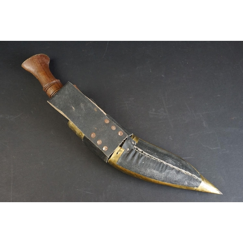 100 - A mid 20th century Kukri knife, decorative dot engraved steel blade, wooden handle with brass fixing... 