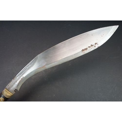 105 - A Kukri knife, dot engraved hollow ground steel blade, horn handle with brass fixings, leather cover... 