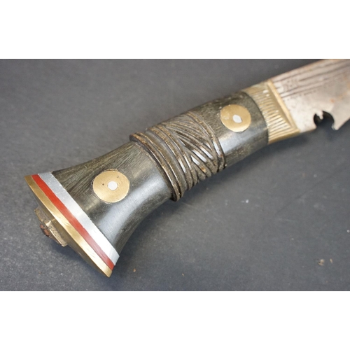 105 - A Kukri knife, dot engraved hollow ground steel blade, horn handle with brass fixings, leather cover... 