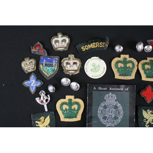 139 - A small collection of mainly British military badges, buttons and cloth patches.