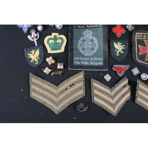 139 - A small collection of mainly British military badges, buttons and cloth patches.