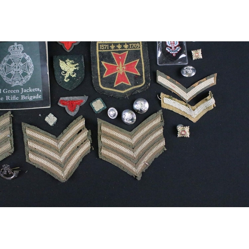 139 - A small collection of mainly British military badges, buttons and cloth patches.