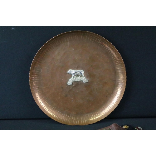 143 - A vintage hammered copper dish badged to the Kenya Regiment together with a quantity of military clo... 