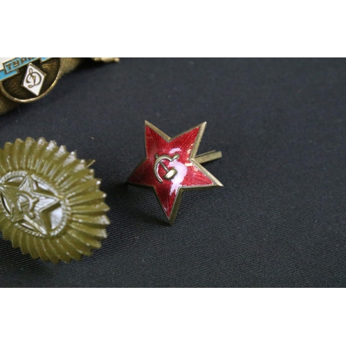 158 - A collection of Russian propaganda badges mounted to military side cap.