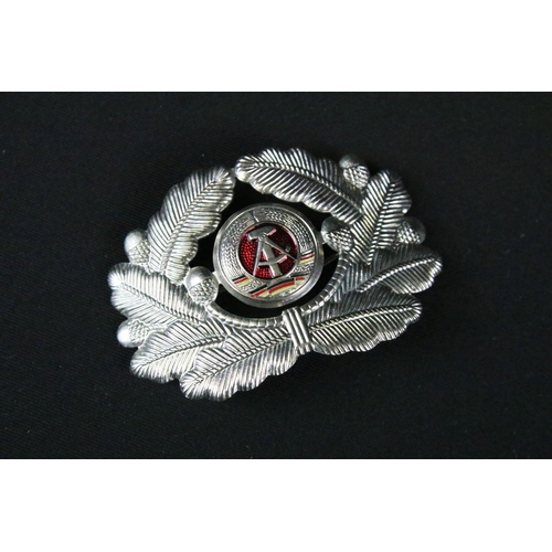 158 - A collection of Russian propaganda badges mounted to military side cap.