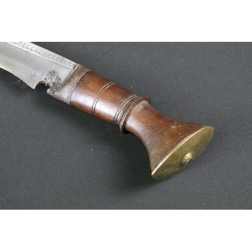 171 - An early to mid 20th century Kukri knife, engraved steel blade, turned wooden handle with flat brass... 