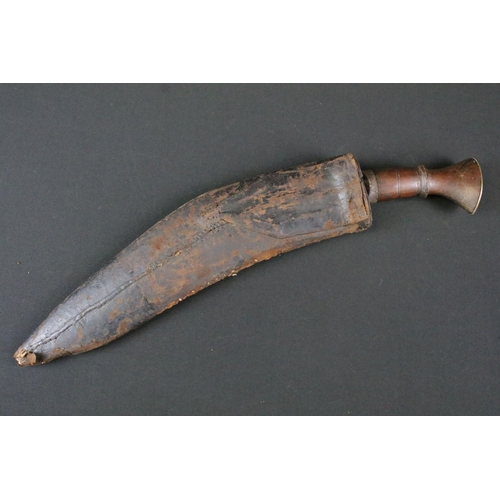 171 - An early to mid 20th century Kukri knife, engraved steel blade, turned wooden handle with flat brass... 