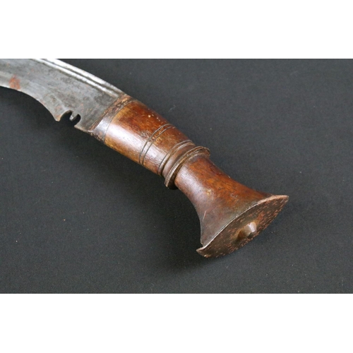 172 - A mid 20th century Kukri knife, steel blade, turned wooden handle, flat white metal pommel, blade me... 