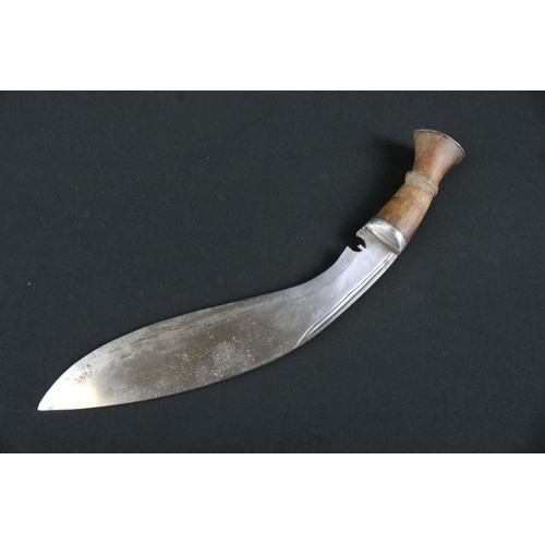 174 - A mid 20th century Gurkha Kukri knife, steel blade, turned wooden handle, white metal flat pommel an... 