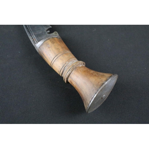 174 - A mid 20th century Gurkha Kukri knife, steel blade, turned wooden handle, white metal flat pommel an... 