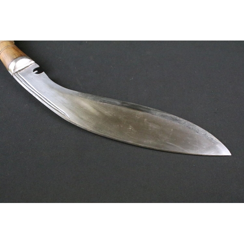 174 - A mid 20th century Gurkha Kukri knife, steel blade, turned wooden handle, white metal flat pommel an... 