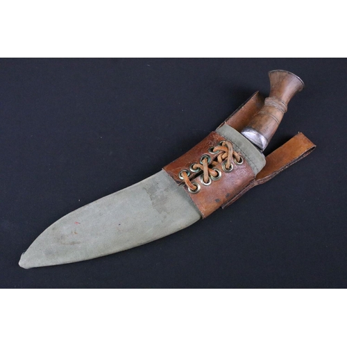 174 - A mid 20th century Gurkha Kukri knife, steel blade, turned wooden handle, white metal flat pommel an... 