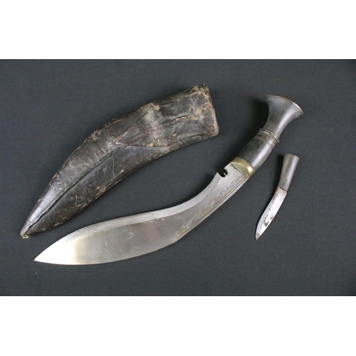 178 - A mid 20th century Kukri knife, steel blade with engraved decoration, turned horn handle, brass flat... 