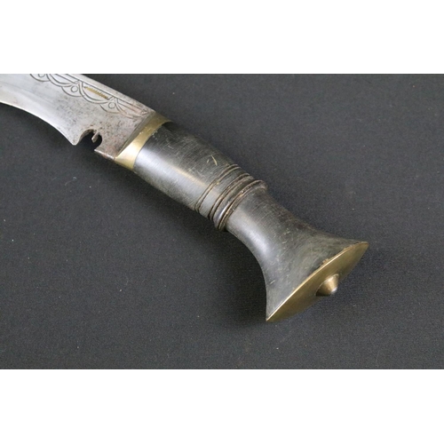 178 - A mid 20th century Kukri knife, steel blade with engraved decoration, turned horn handle, brass flat... 