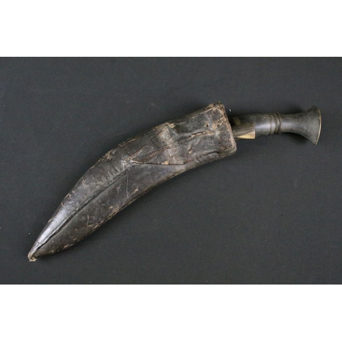 178 - A mid 20th century Kukri knife, steel blade with engraved decoration, turned horn handle, brass flat... 