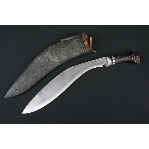 180 - A mid 20th century Kukri knife, engraved steel blade, turned wooden handle with inlayed decoration, ... 