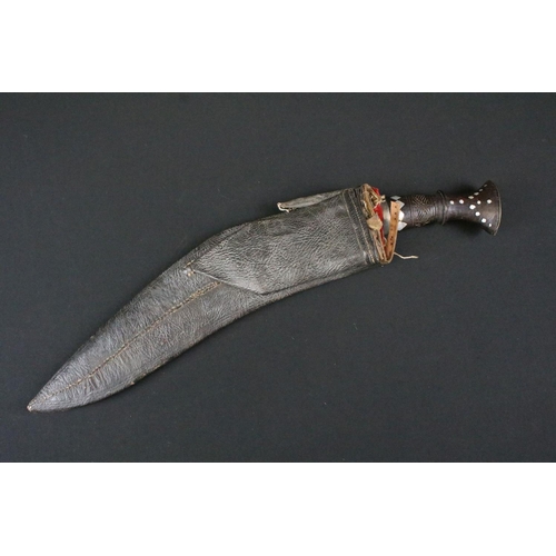 180 - A mid 20th century Kukri knife, engraved steel blade, turned wooden handle with inlayed decoration, ... 