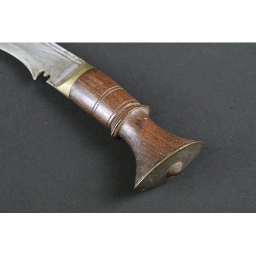 182 - A mid 20th century Kukri knife, steel blade with fullered groove, turned wooden handle, brass flat p... 