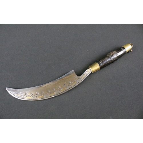 191 - A highly decorative Kukri style knife, decoratively engraved steel curved blade, brass fittings with... 