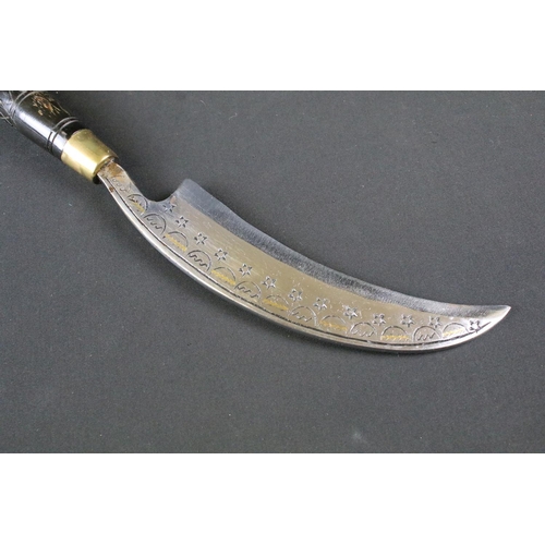 191 - A highly decorative Kukri style knife, decoratively engraved steel curved blade, brass fittings with... 