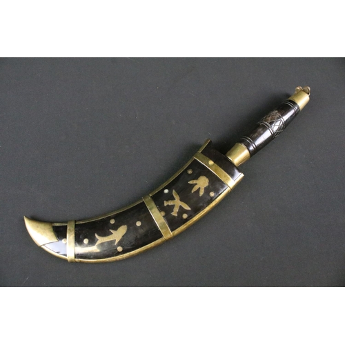 191 - A highly decorative Kukri style knife, decoratively engraved steel curved blade, brass fittings with... 