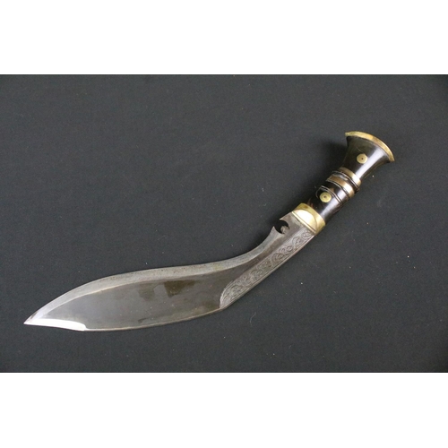 216 - A late 20th century small Kukri knife, engraved steel blade, turned wooden handle with brass fitting... 