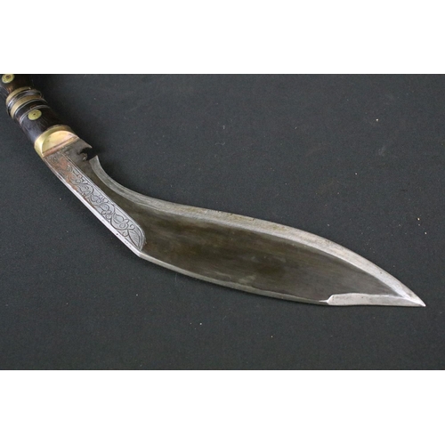 216 - A late 20th century small Kukri knife, engraved steel blade, turned wooden handle with brass fitting... 