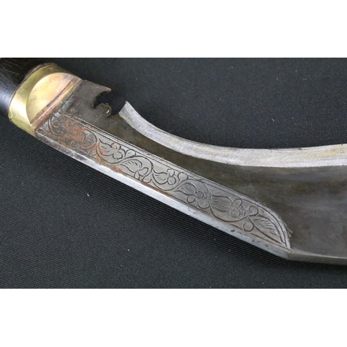 216 - A late 20th century small Kukri knife, engraved steel blade, turned wooden handle with brass fitting... 