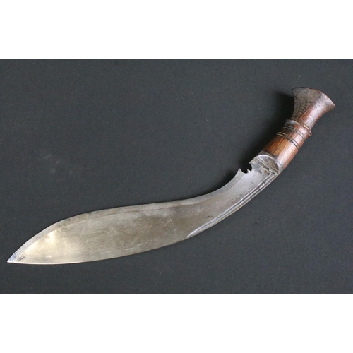 231 - A mid to late 20th century Kukri knife, steel blade with twin grooved fullers, turned wooden handle,... 