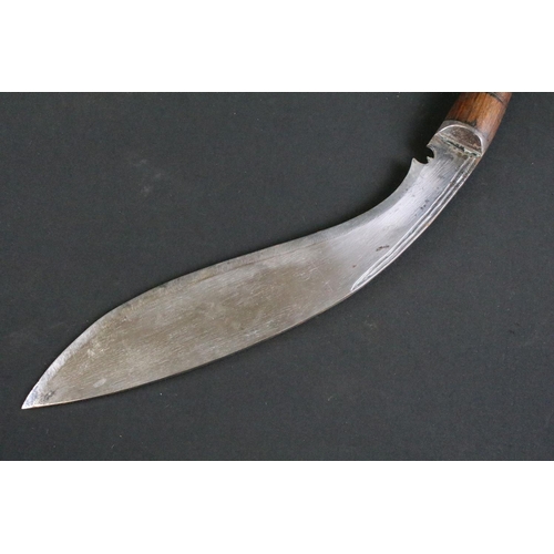 231 - A mid to late 20th century Kukri knife, steel blade with twin grooved fullers, turned wooden handle,... 