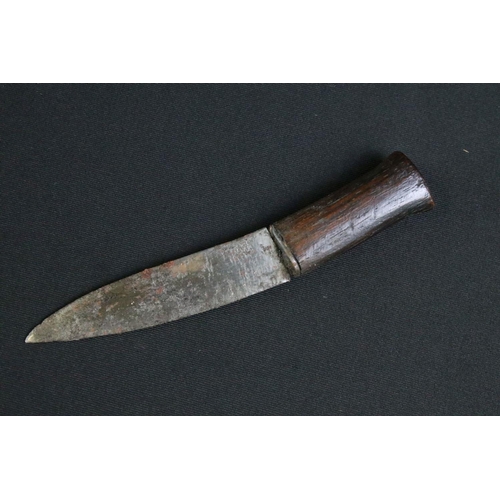 231 - A mid to late 20th century Kukri knife, steel blade with twin grooved fullers, turned wooden handle,... 