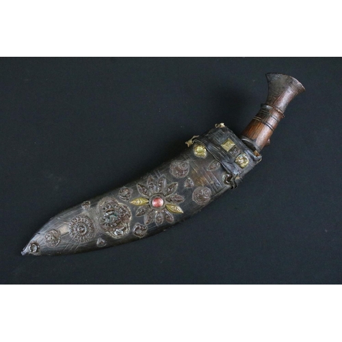 231 - A mid to late 20th century Kukri knife, steel blade with twin grooved fullers, turned wooden handle,... 