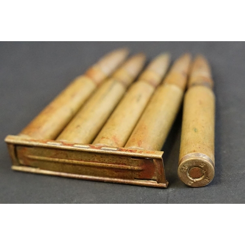 261 - A group of four Lee Enfield .303 rifle training clips, each clip containing five rounds together wit... 