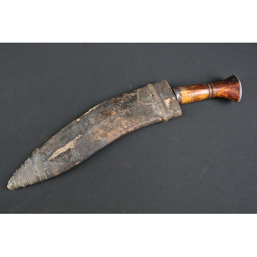 296 - A mid 20th century Kukri knife, steel blade with single grooved fuller stamped A.C. 1945, turned woo... 