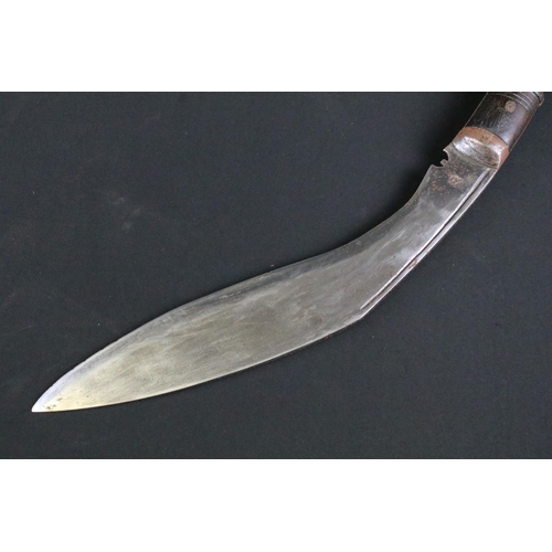 298 - An early to mid 20th century Kukri knife, steel blade with single groove fuller and sun face stamp, ... 